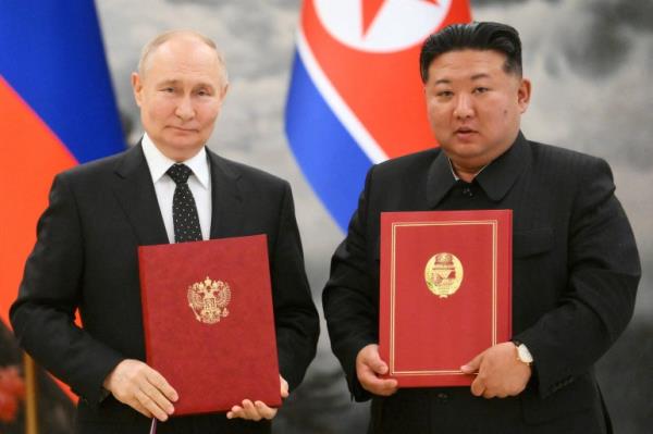 俄罗斯总统弗拉基米尔·普京与朝鲜领导人金正恩在签署双边协议时合影